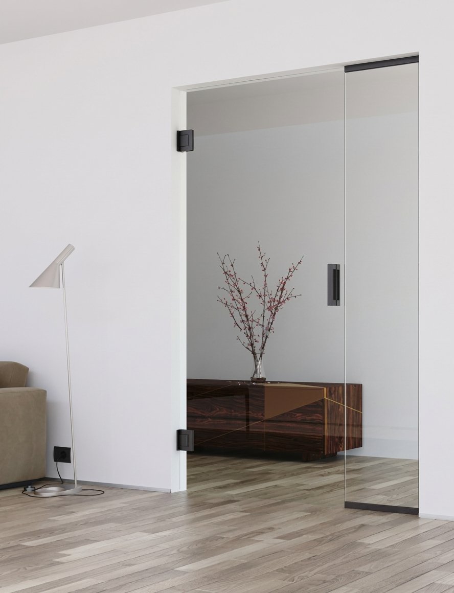 Klare Ganzglastür mit schwarzen Bändern im Wohnraum